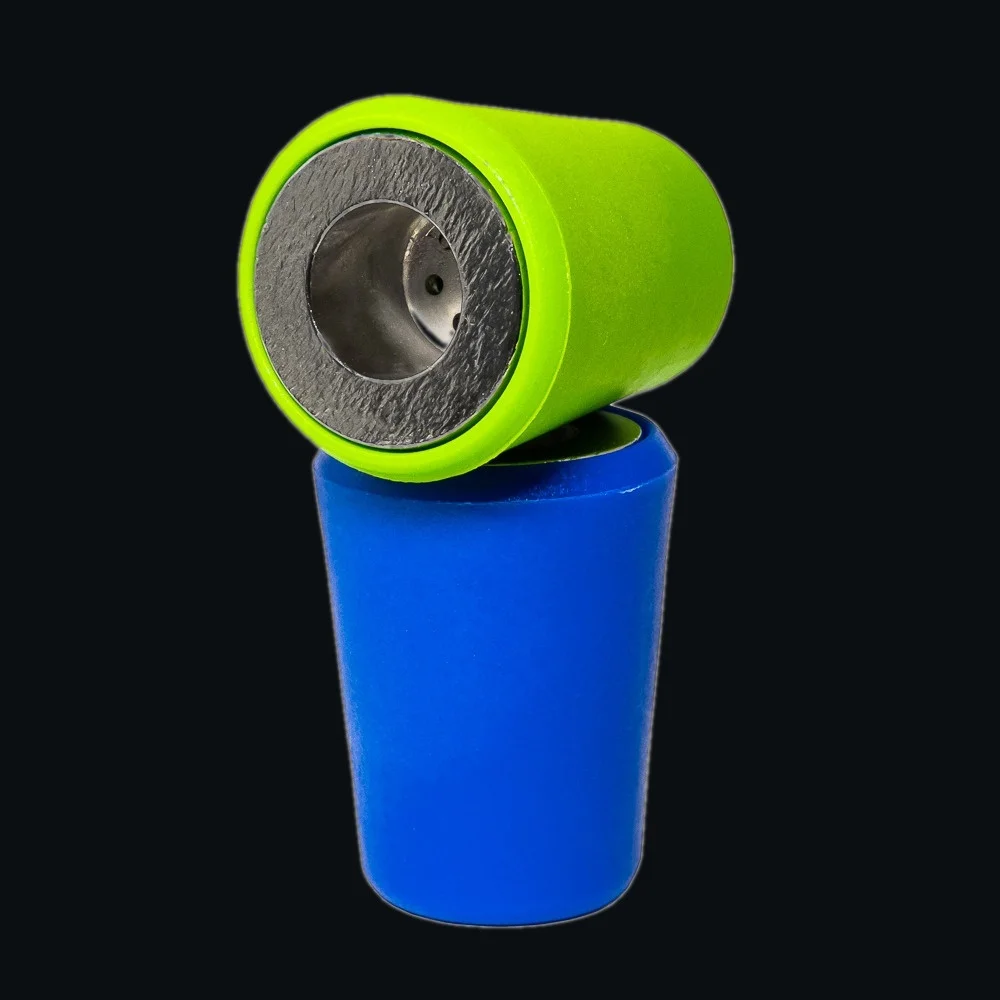 Product photo of the Universal Plug cap in green and blue, shown at an angle with its metal mesh insert visible